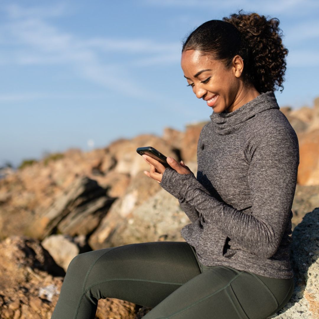 women looking at phone in nature